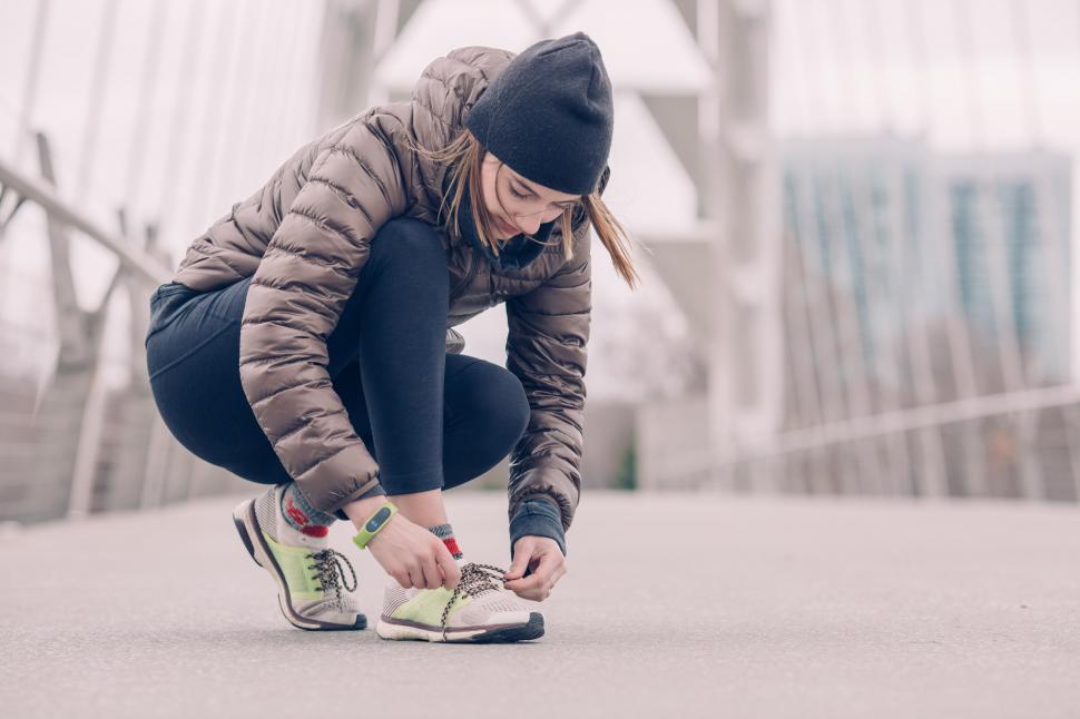 Femme accroupie laçant ses chaussures de course à pied